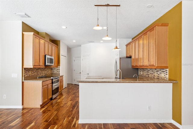 kitchen featuring visible vents, dark wood-style flooring, a peninsula, and stainless steel appliances