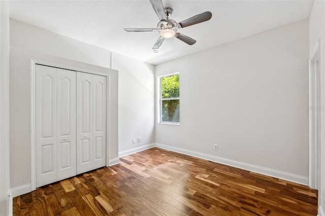 unfurnished bedroom with baseboards, ceiling fan, a closet, and wood finished floors