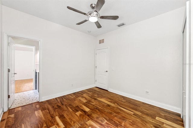 unfurnished bedroom featuring visible vents, baseboards, and wood finished floors