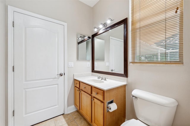 half bathroom featuring toilet, tile patterned flooring, and vanity