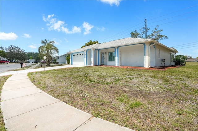 ranch-style home featuring a front yard, concrete driveway, and an attached garage