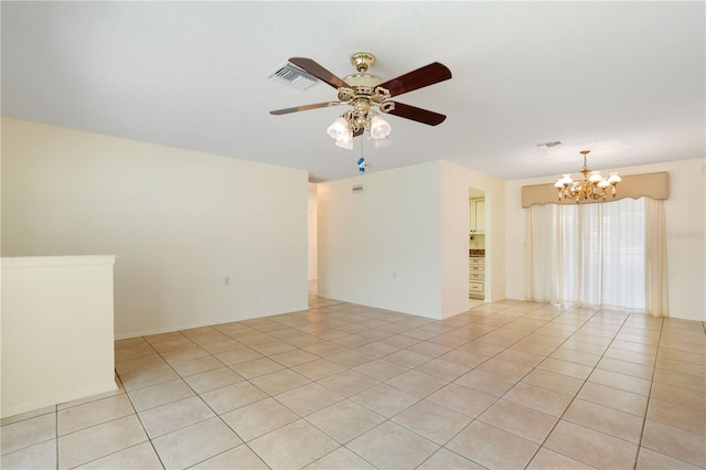 unfurnished room featuring ceiling fan with notable chandelier, visible vents, and light tile patterned floors