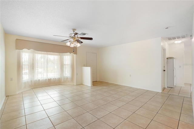 spare room featuring a ceiling fan, light tile patterned floors, and visible vents