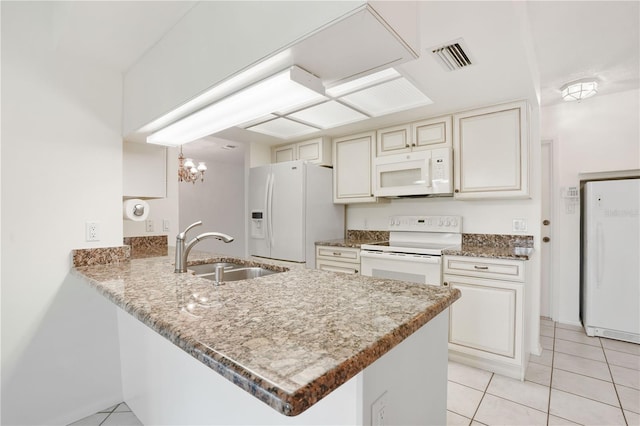 kitchen with white appliances, light tile patterned floors, a sink, visible vents, and a peninsula