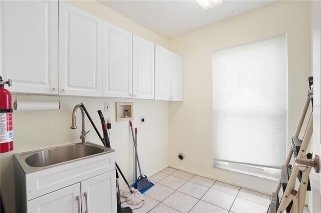 washroom with light tile patterned floors, a sink, cabinet space, electric dryer hookup, and washer hookup