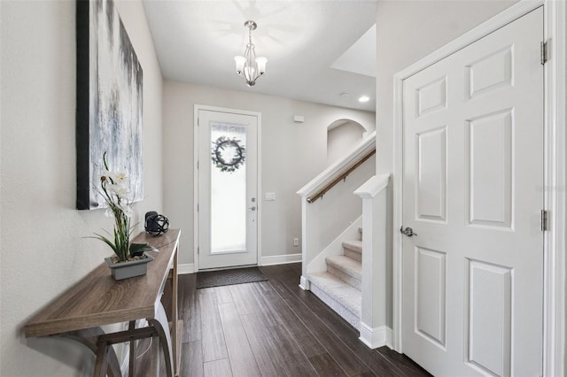 foyer entrance featuring dark wood finished floors, baseboards, recessed lighting, a chandelier, and stairway