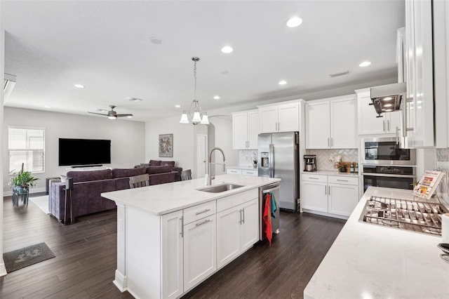 kitchen featuring dark wood finished floors, visible vents, a sink, tasteful backsplash, and appliances with stainless steel finishes