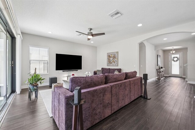 living area featuring arched walkways, dark wood-style flooring, visible vents, recessed lighting, and a ceiling fan