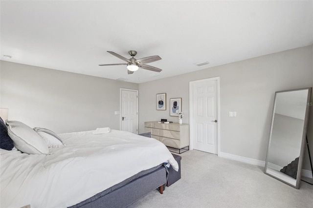 bedroom featuring visible vents, a ceiling fan, baseboards, and light colored carpet