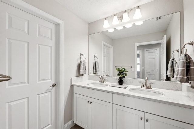 full bathroom with a sink and double vanity