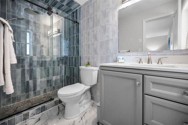 full bath with tile walls, toilet, marble finish floor, tiled shower, and vanity
