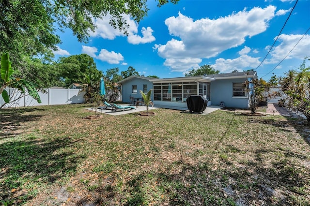 back of property featuring a sunroom, stucco siding, a lawn, a fenced backyard, and a patio area