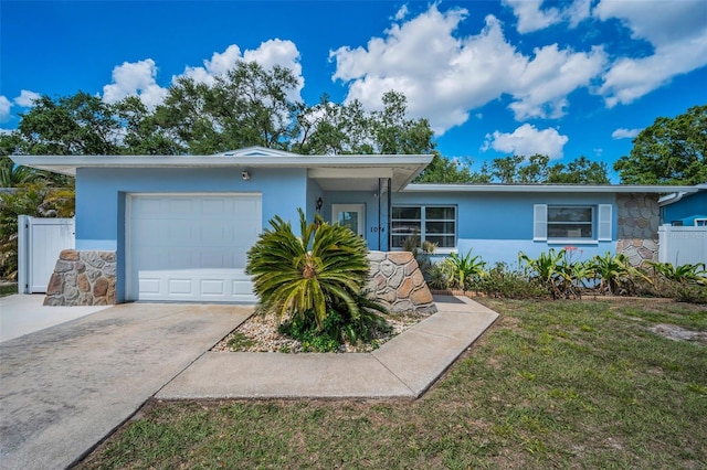 single story home featuring fence, an attached garage, concrete driveway, stucco siding, and a front yard