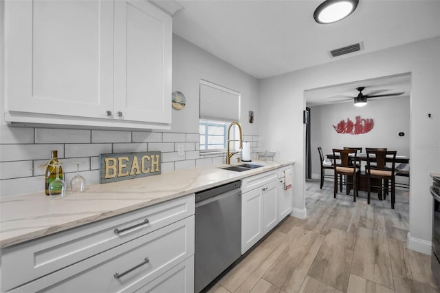 kitchen with a sink, stainless steel dishwasher, visible vents, and white cabinets
