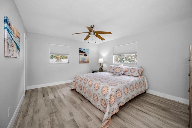 bedroom with baseboards, ceiling fan, and wood finished floors