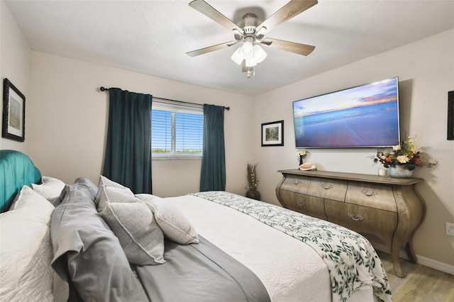 bedroom with light wood-style floors, baseboards, and ceiling fan