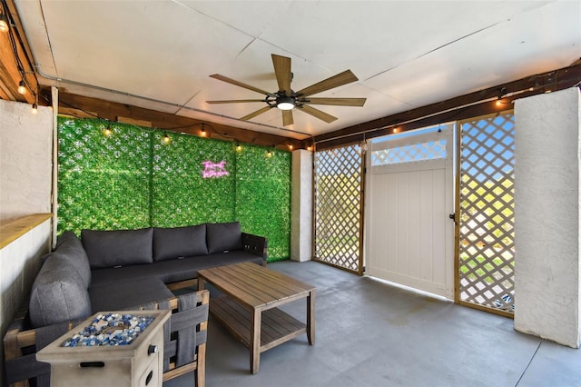 sunroom featuring a ceiling fan and an outdoor living space with a fire pit