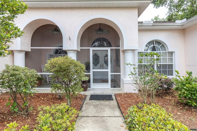 property entrance featuring stucco siding and ceiling fan
