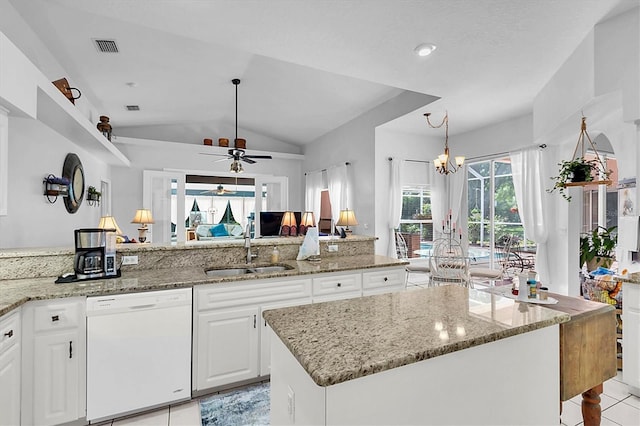 kitchen with lofted ceiling, a sink, dishwasher, white cabinets, and light stone countertops