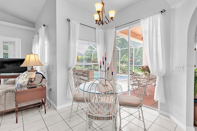 dining area with arched walkways, vaulted ceiling, a chandelier, and light tile patterned floors