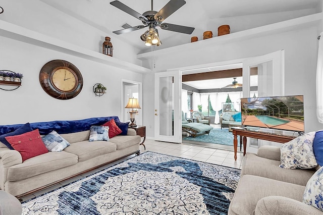 living room with baseboards, lofted ceiling, ceiling fan, and light tile patterned floors