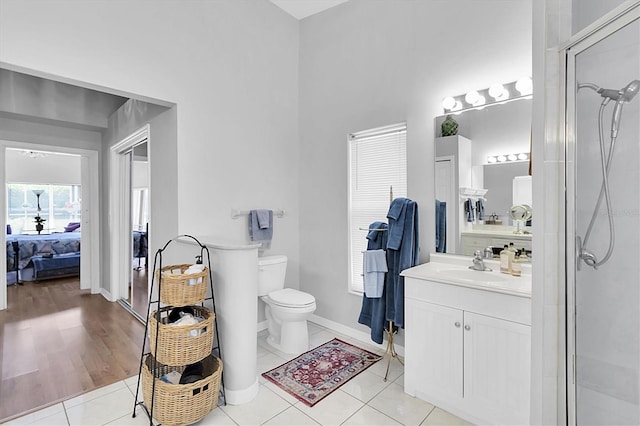 ensuite bathroom with vanity, tile patterned flooring, and a shower with shower door