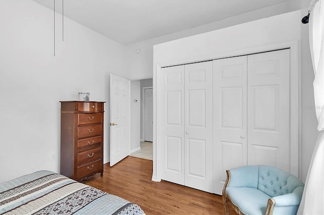 bedroom featuring light wood finished floors and a closet