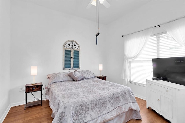 bedroom featuring baseboards, wood finished floors, and ceiling fan