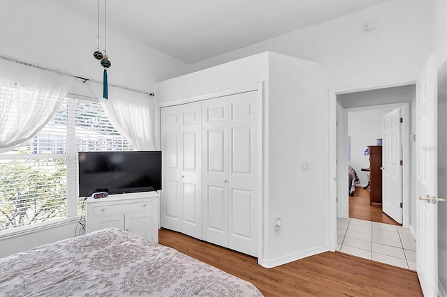 bedroom with baseboards, a closet, and wood finished floors