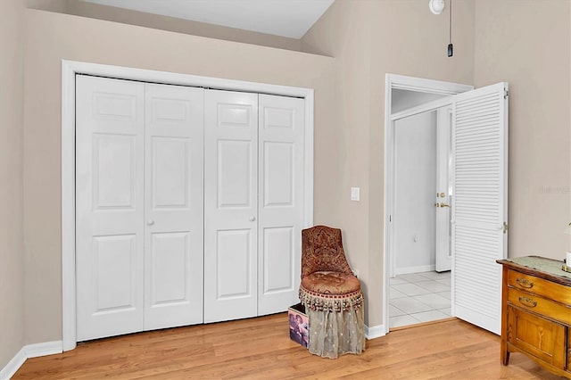 living area featuring baseboards and light wood-type flooring