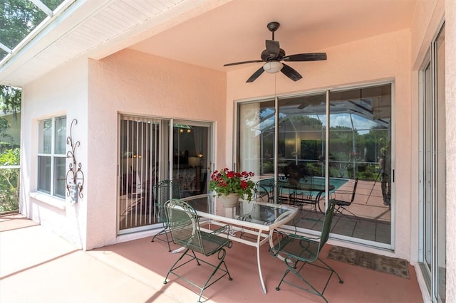 view of patio with glass enclosure and ceiling fan