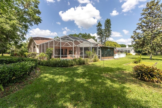 back of house with glass enclosure and a yard