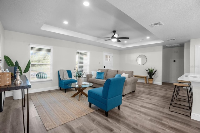 3416 Lema Dr, Spring Hill, FL 34609 - living room featuring baseboards, a tray ceiling, wood finished floors, and ceiling fan