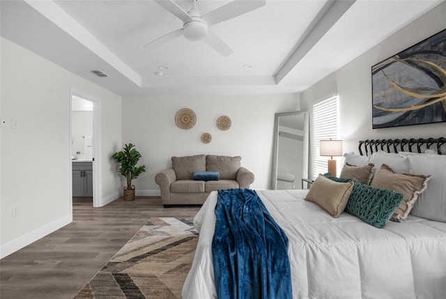 3416 Lema Dr, Spring Hill, FL 34609 - bedroom featuring a tray ceiling, wood finished floors, ensuite bathroom, baseboards, and visible vents