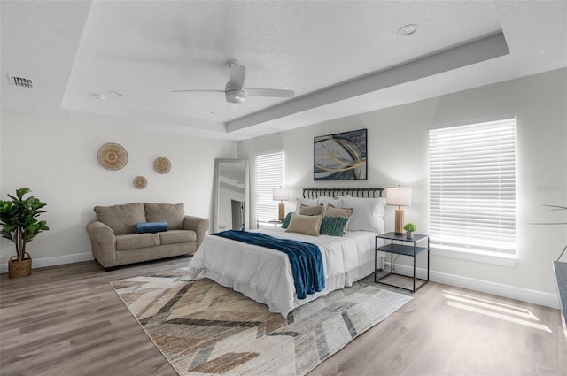 3416 Lema Dr, Spring Hill, FL 34609 - bedroom with a tray ceiling, baseboards, visible vents, and wood finished floors