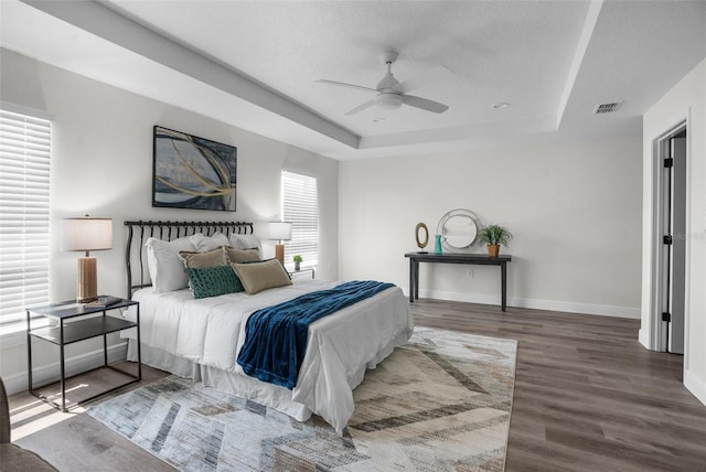 3416 Lema Dr, Spring Hill, FL 34609 - bedroom featuring visible vents, baseboards, wood finished floors, a ceiling fan, and a tray ceiling