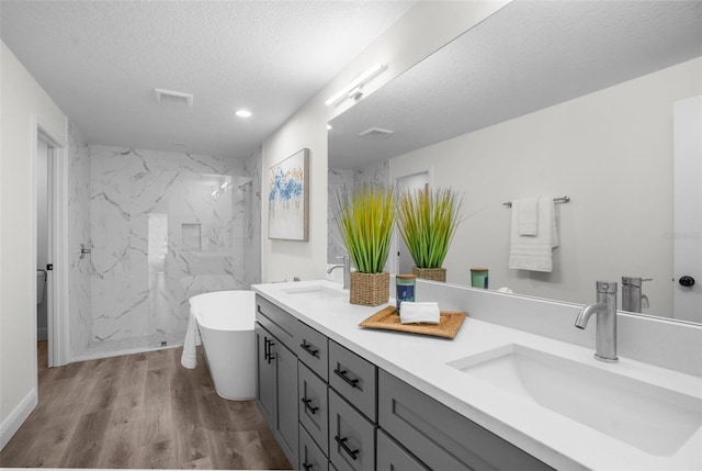 3416 Lema Dr, Spring Hill, FL 34609 - bathroom featuring double vanity, wood finished floors, a sink, and a textured ceiling