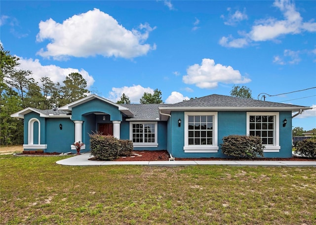 ranch-style home with a front lawn and stucco siding