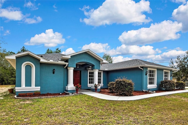 ranch-style home featuring stucco siding and a front yard