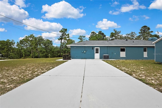view of front of home with driveway, a front yard, and central AC unit