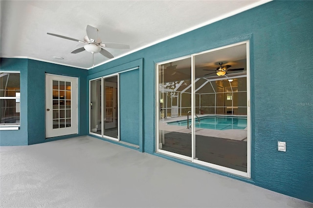 view of patio with ceiling fan and an outdoor pool
