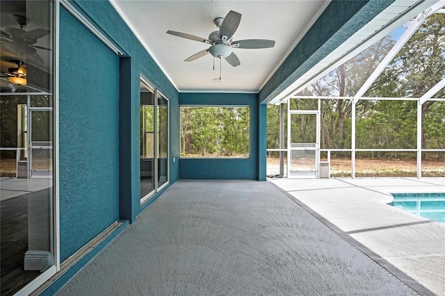 swimming pool featuring a ceiling fan, a patio area, and glass enclosure