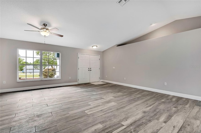 unfurnished living room with wood finished floors, lofted ceiling, ceiling fan, and baseboards