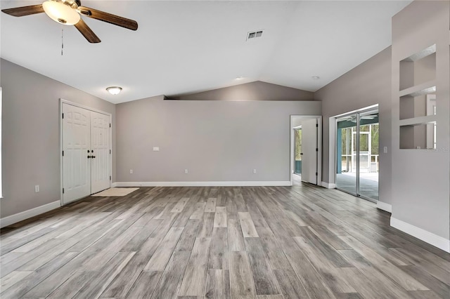 unfurnished living room with ceiling fan, vaulted ceiling, wood finished floors, and baseboards