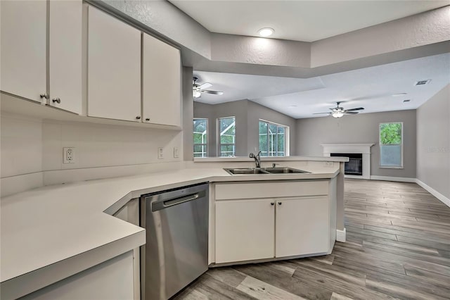 kitchen with stainless steel dishwasher, a sink, ceiling fan, and light countertops