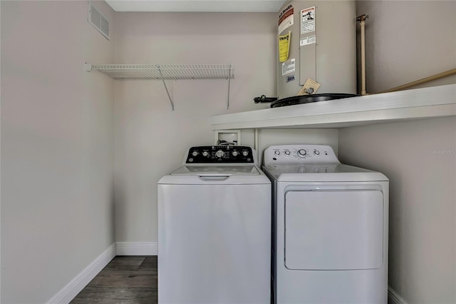 laundry room featuring water heater, washer and clothes dryer, baseboards, and wood finished floors
