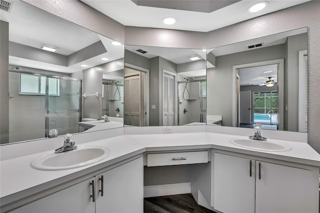 bathroom with a shower stall, recessed lighting, a ceiling fan, vanity, and wood finished floors