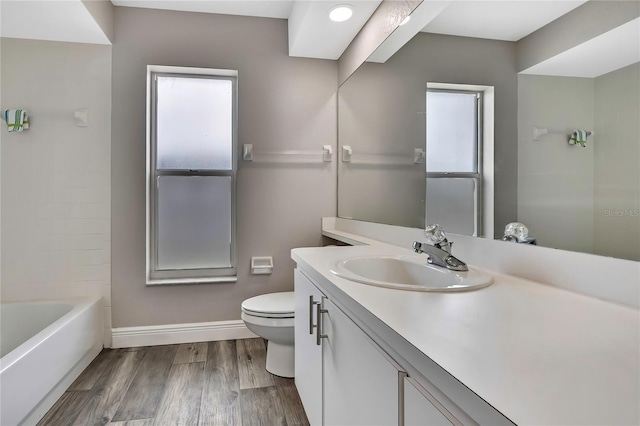 full bathroom with toilet, wood finished floors, baseboards, and vanity