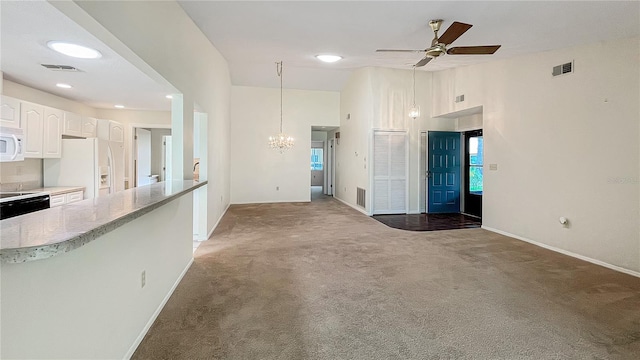 unfurnished living room featuring visible vents, ceiling fan with notable chandelier, and light colored carpet