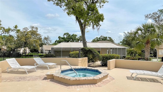 view of swimming pool featuring fence, glass enclosure, a hot tub, and a patio